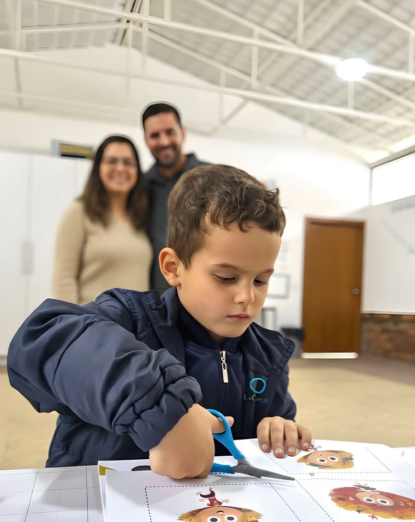 Padre y madre de familia viendo a su hijo en trabajos de motricidad fina